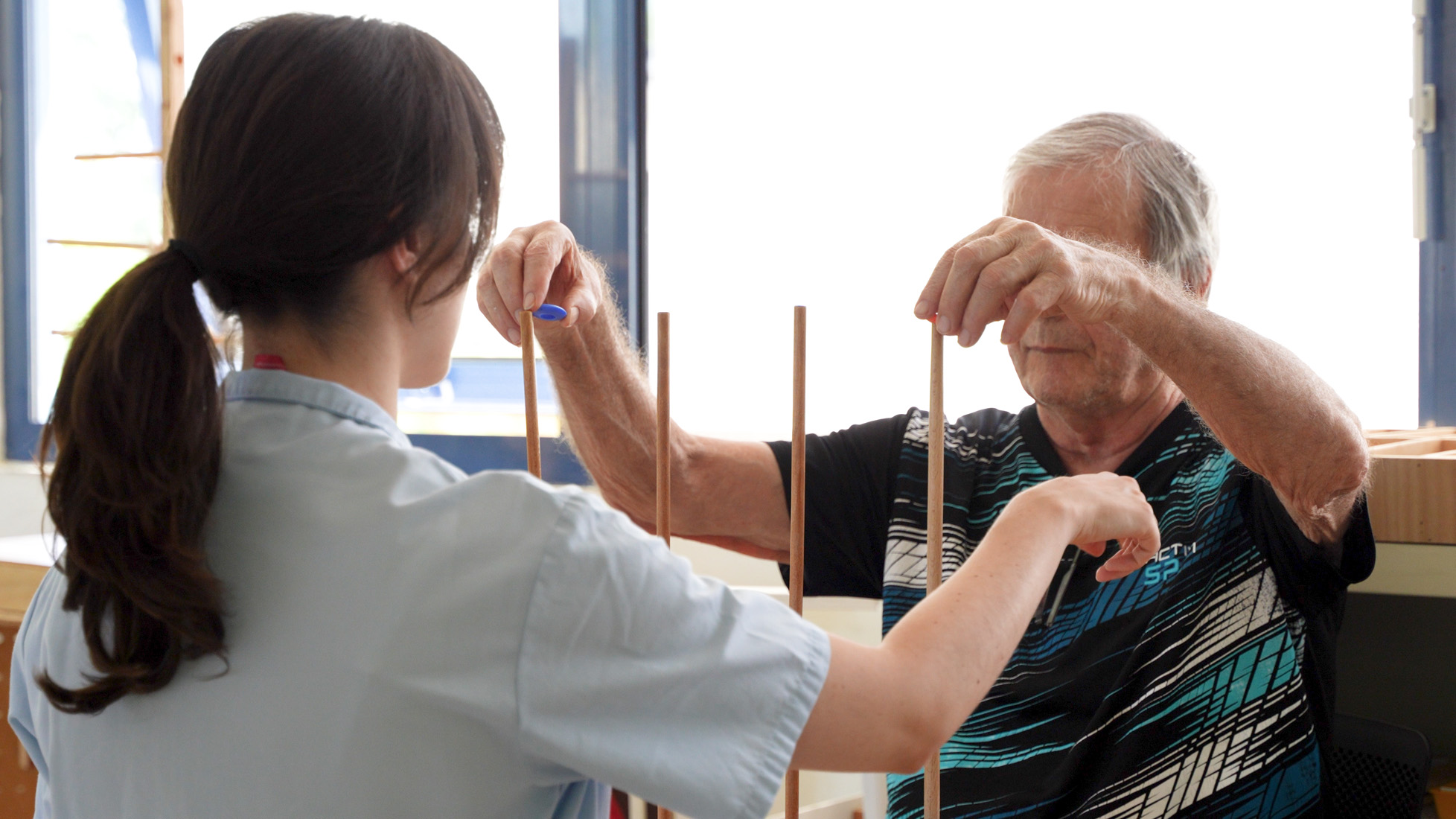 Elderly man doing physical therapy with therapist